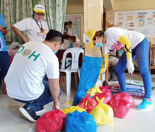 Fr. Andrei Paz and friends bagging groceries to be distributed to people in need.